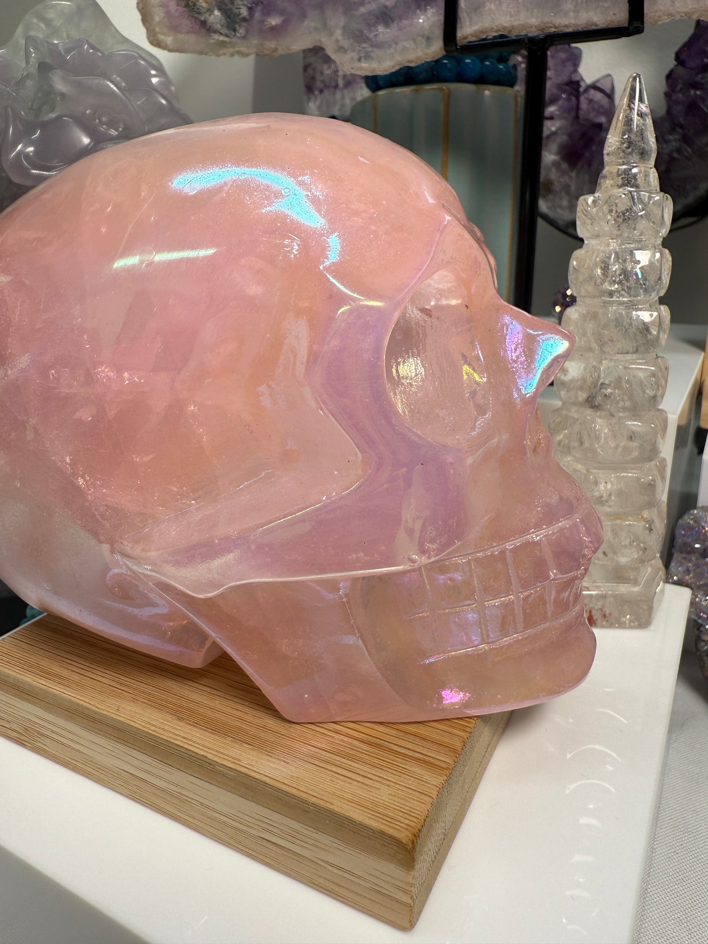 Large Pink Aura Rose Quartz crystal skull, measuring approximately 5 x 5.5 inches and weighing 4 lbs. Features soft pink coloration and a glowing, iridescent surface. Displayed as a carved decorative stone with heart-focused elegance.