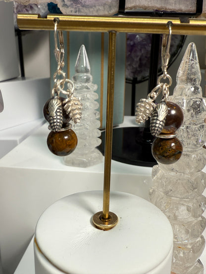 Earrings with round Brown Opal and Pietersite stones, finished with detailed silver pine cone and corn cob motifs. Styled as earthy, fall-inspired jewelry.