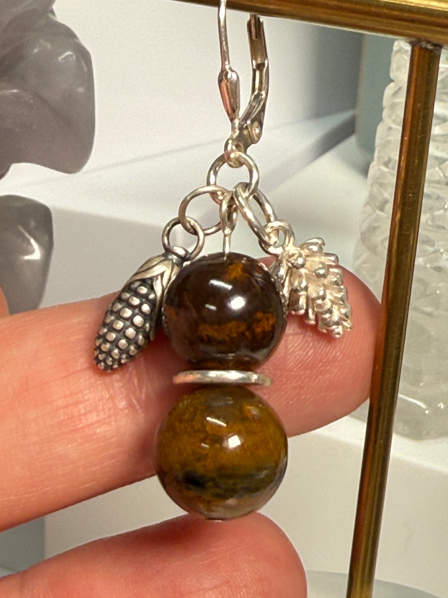 Earrings with round Brown Opal and Pietersite stones, finished with detailed silver pine cone and corn cob motifs. Styled as earthy, fall-inspired jewelry.