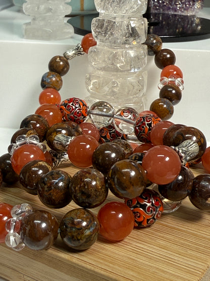 Crystal bracelet featuring South Red Agate, Pietersite, Rutile-in-Quartz, and Brown Opal, with 925 sterling silver cabbage and enameled beads, accented by a clear quartz ring. A sculptural fine jewelry piece symbolizing growth, clarity, and inner resilience.